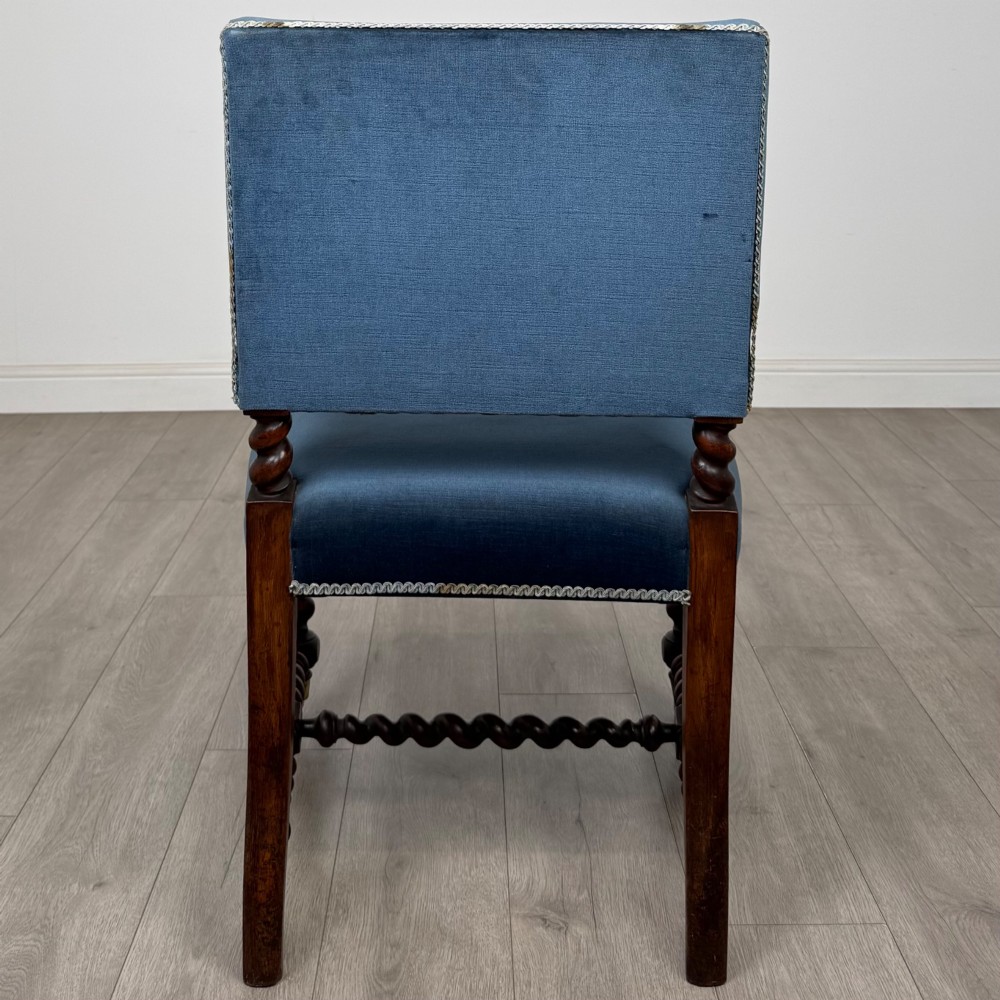 A nineteenth-century dark oak armchair featuring barley twist legs and stretchers, blue fabric upholstery, and brass front castors. View IV