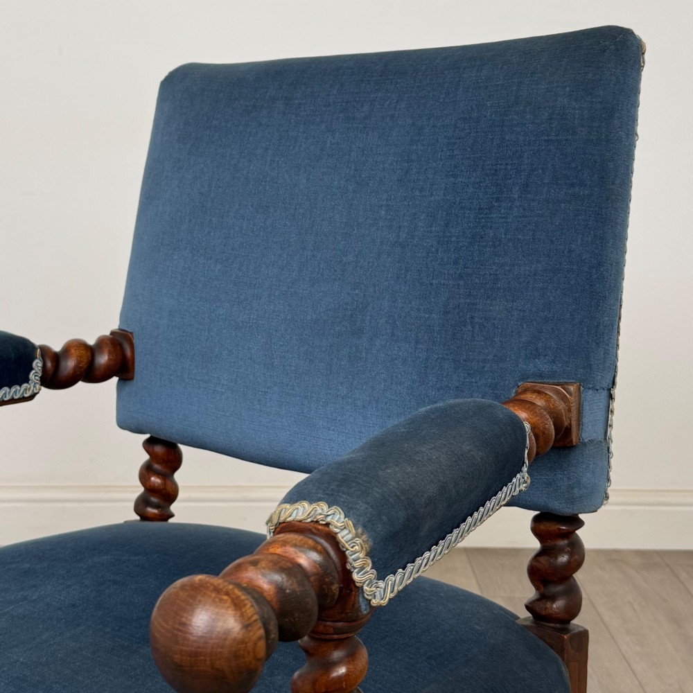 A nineteenth-century dark oak armchair featuring barley twist legs and stretchers, blue fabric upholstery, and brass front castors. View IX