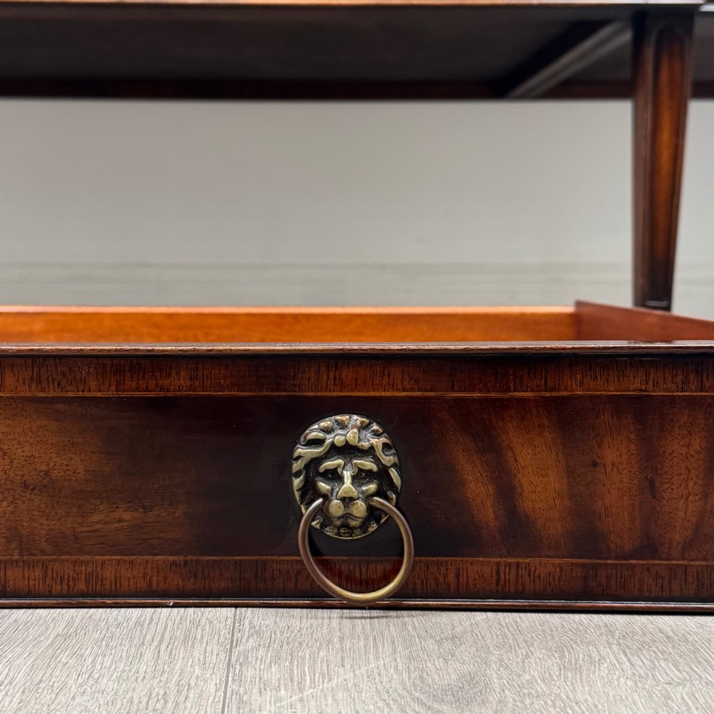 A 20th-century flame mahogany sideboard featuring a bow front design, drawers, cupboard doors, brass lion mask ring handles, and square tapered legs. View XII