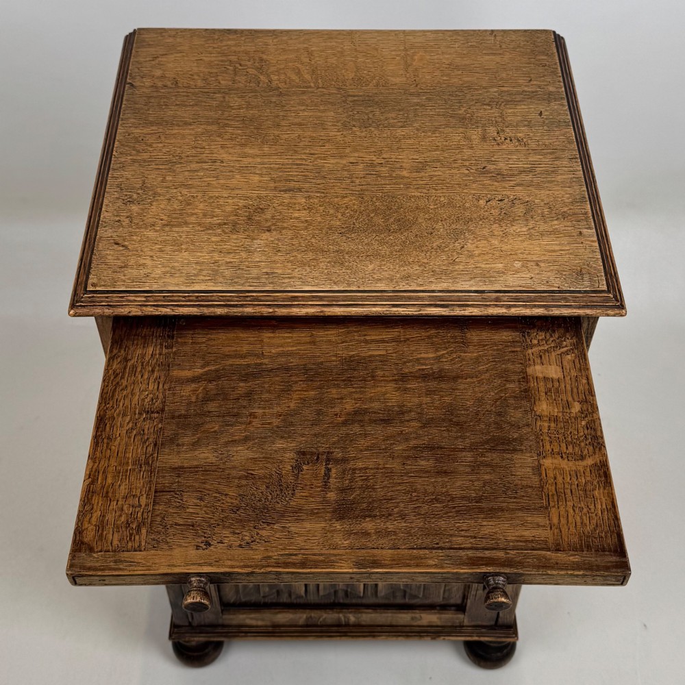 A small Edwardian carved dark oak cabinet with a single top drawer, a lower cupboard door, turned wooden knobs, and bun feet. View XI