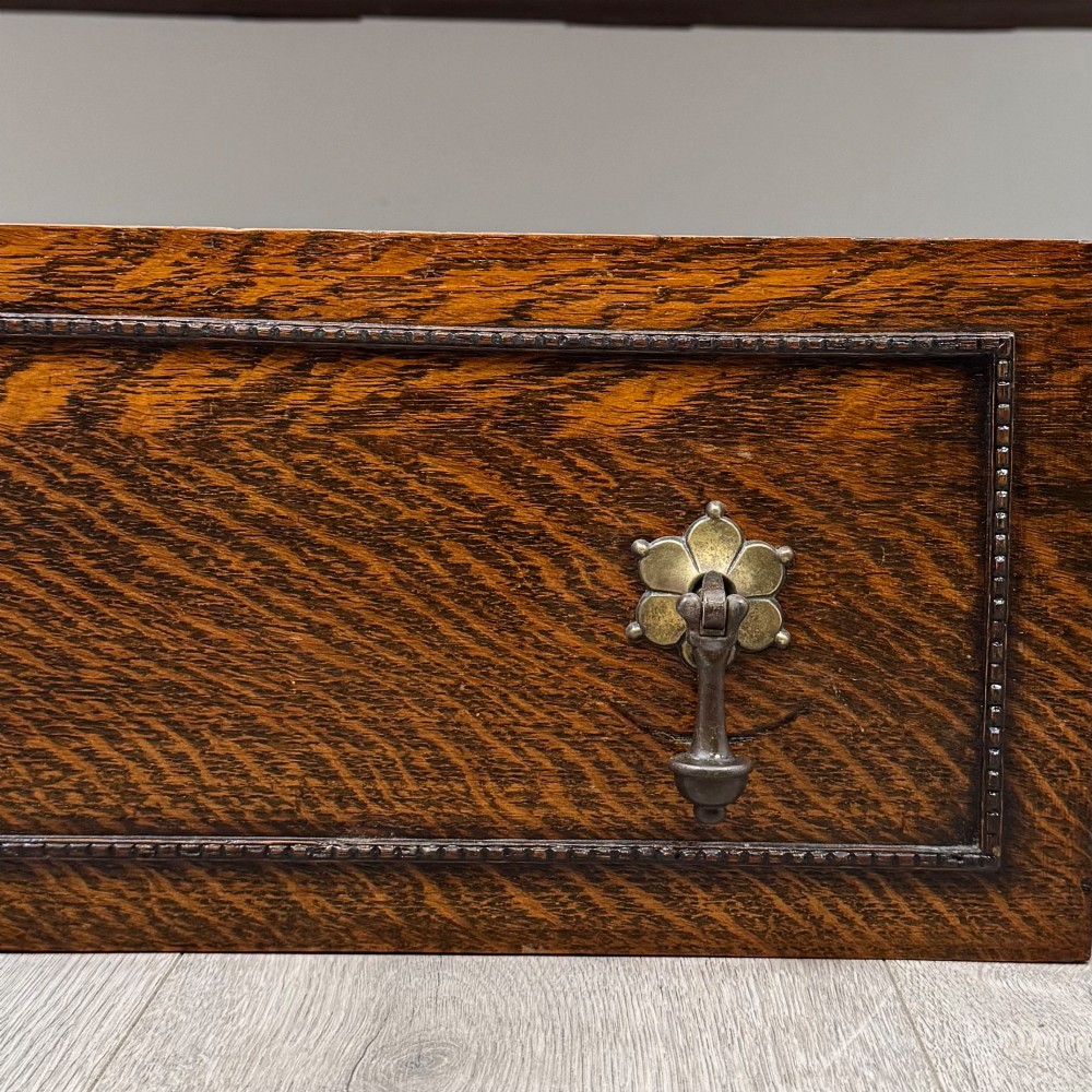 An Edwardian dark oak sideboard featuring two central drawers flanked by cupboard doors, raised on turned front legs with a low back gallery. View XII