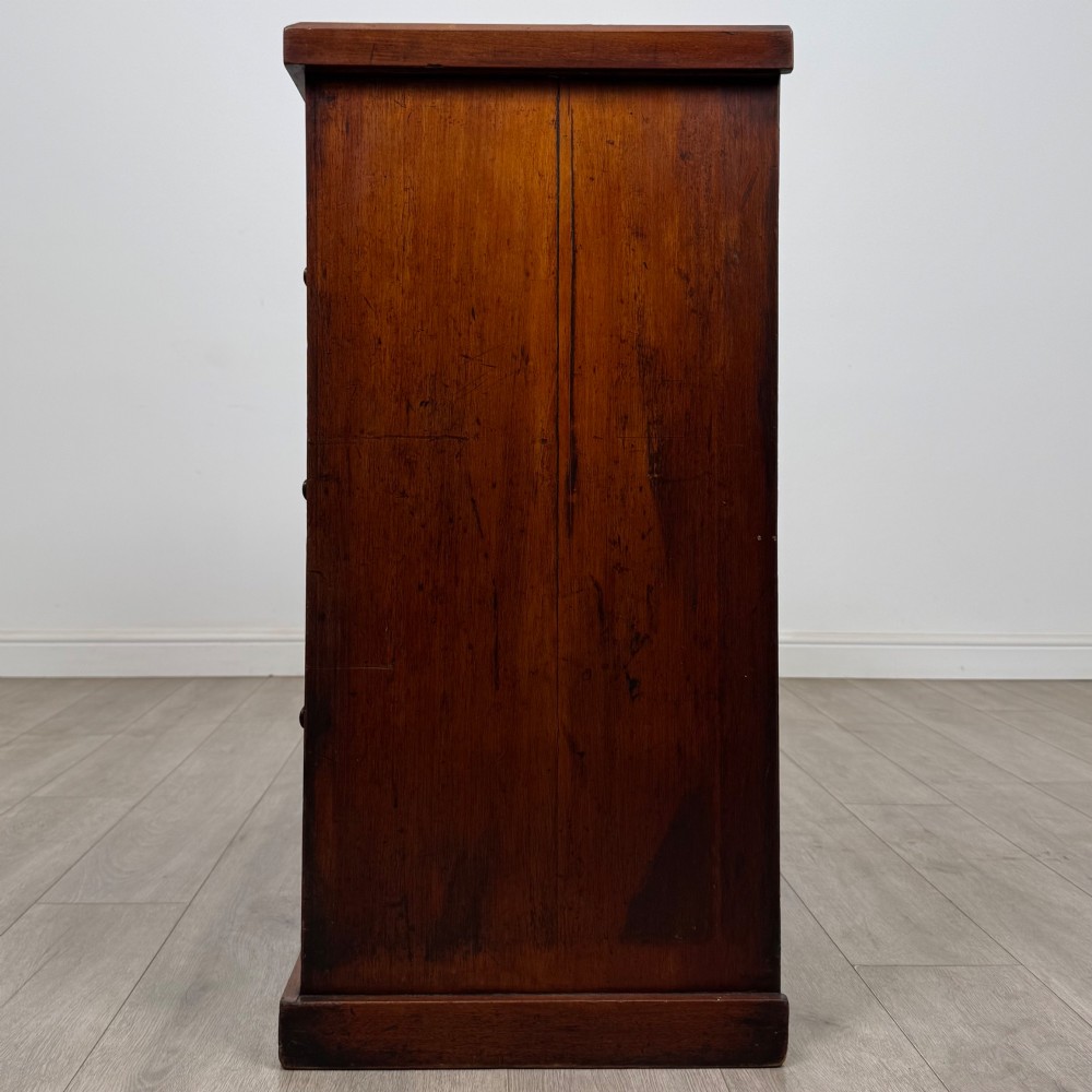 A nineteenth-century Victorian mahogany chest of drawers featuring a two over three drawer layout with turned wooden knobs and a plinth base. View III