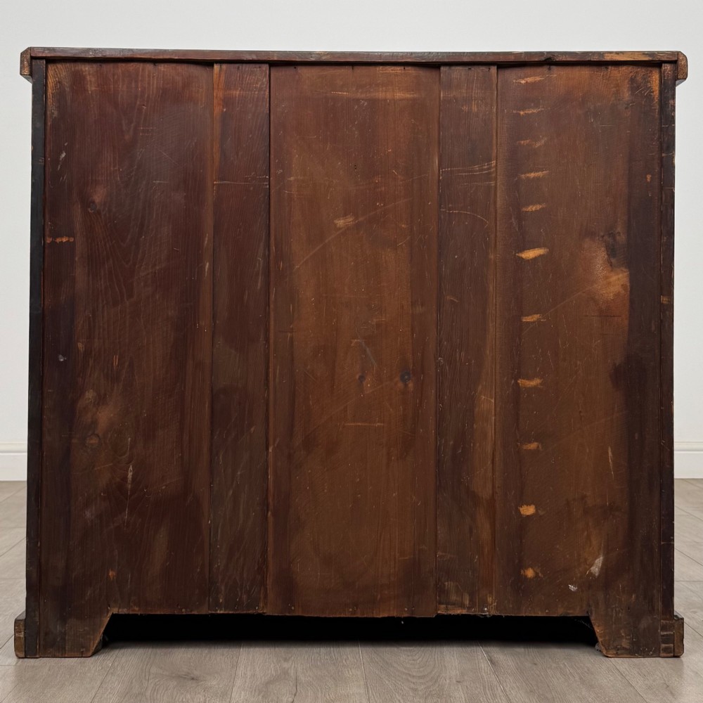 A nineteenth-century Victorian mahogany chest of drawers featuring a two over three drawer layout with turned wooden knobs and a plinth base. View V