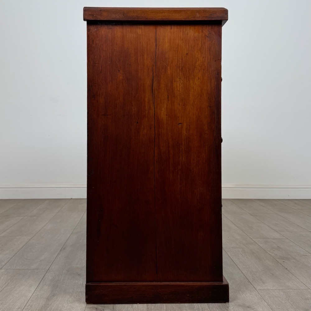 A nineteenth-century Victorian mahogany chest of drawers featuring a two over three drawer layout with turned wooden knobs and a plinth base. View VII