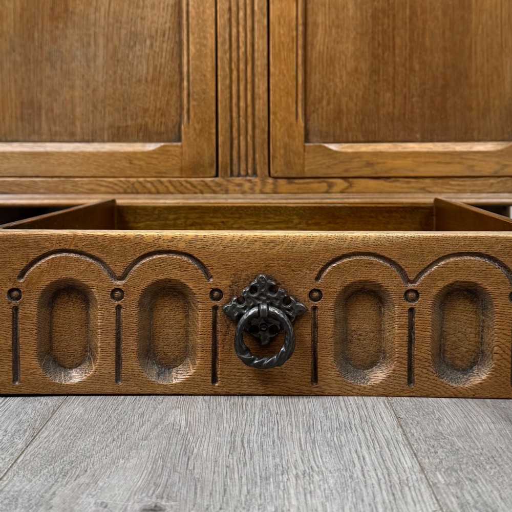 A twentieth-century golden oak court cupboard featuring carved panels, leaded glass side doors, and turned bulbous supports. View XII