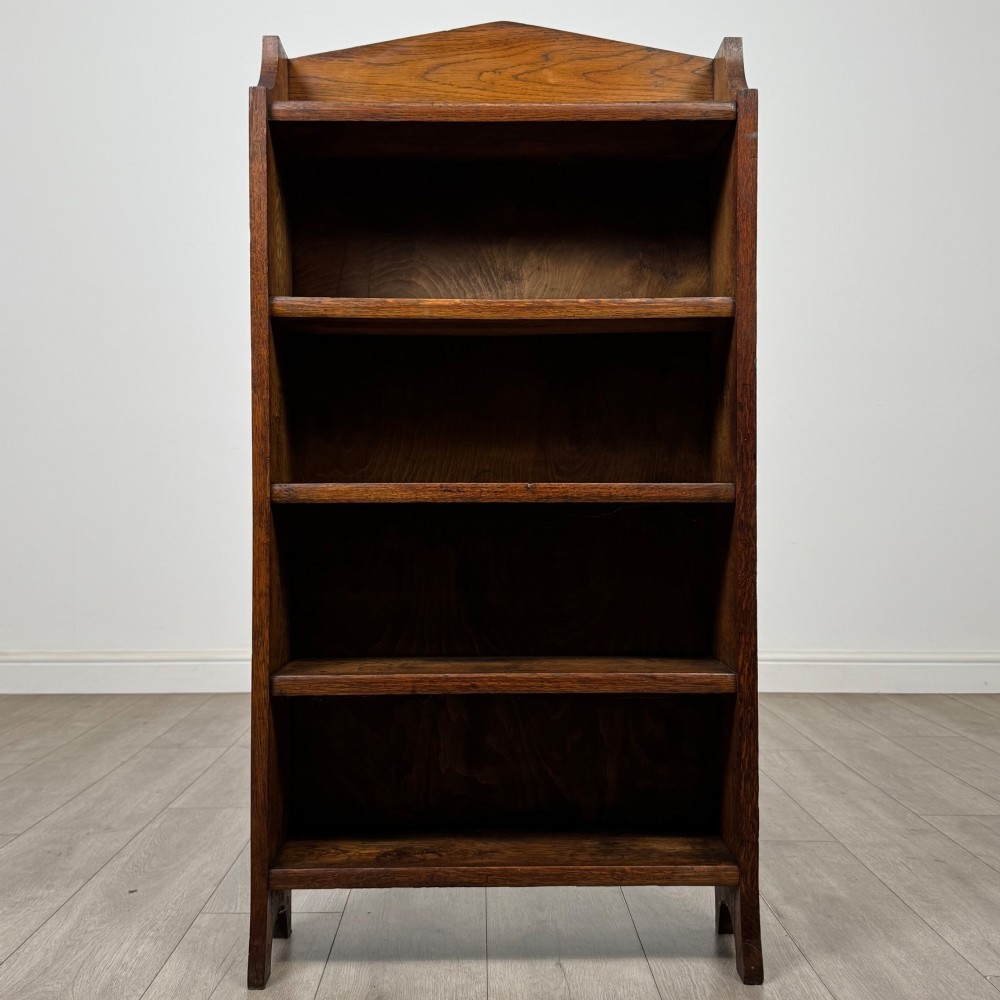 A freestanding Edwardian open oak bookcase featuring four tiers of shelves and a gabled top gallery. View II