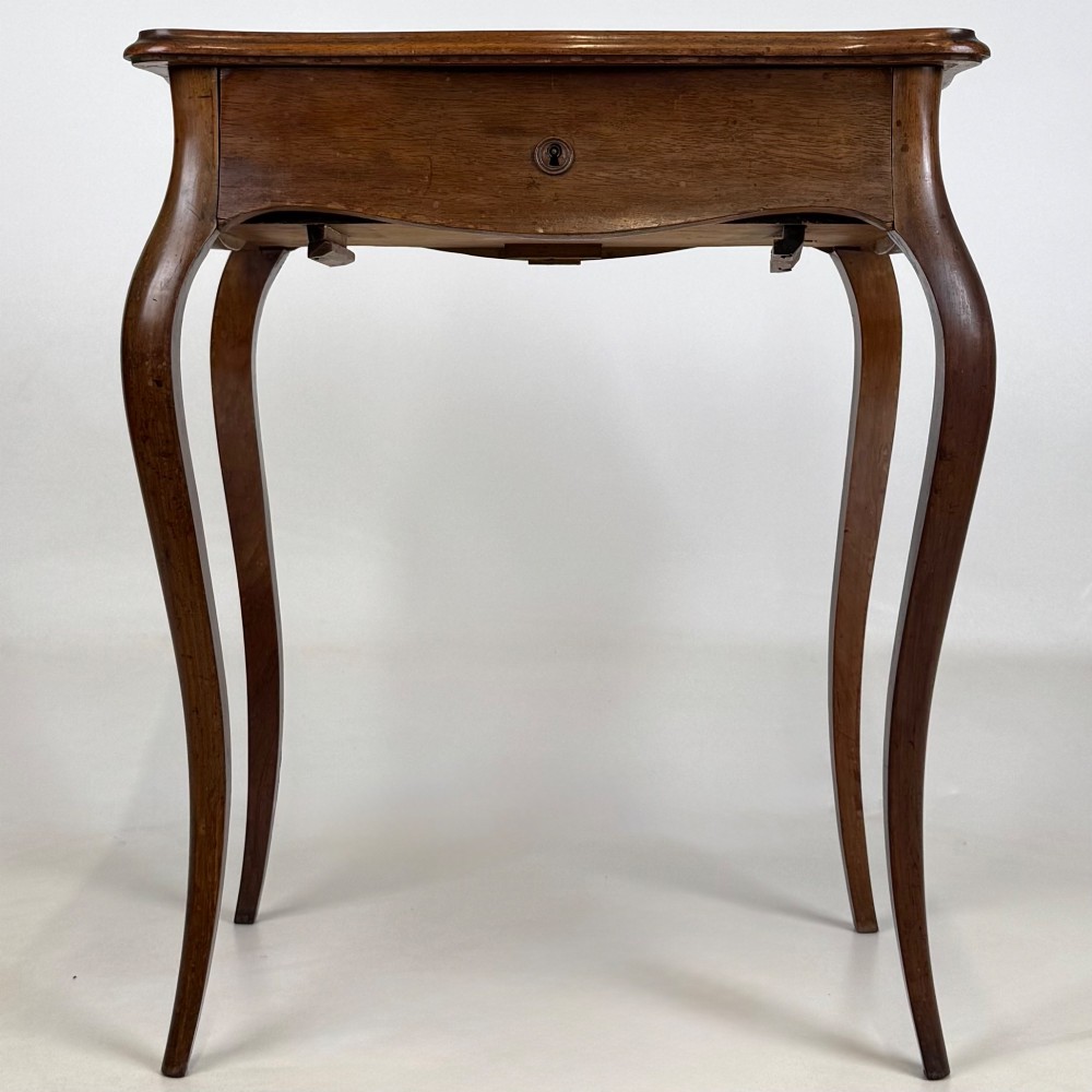 A 19th-century French mahogany side table featuring high cabriole legs, a single frieze drawer with a brass keyhole, and a shaped apron.