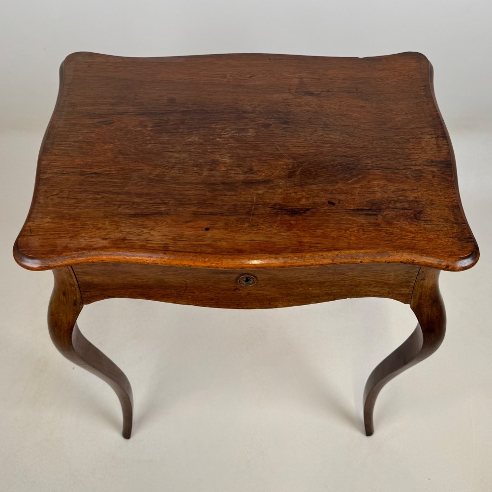 A 19th-century French mahogany side table featuring high cabriole legs, a single frieze drawer with a brass keyhole, and a shaped apron. View X