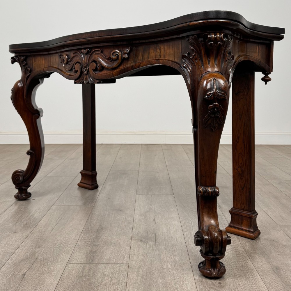 A 19th-century Victorian rosewood side table featuring hand-carved C-scroll ornament, a serpentine apron, and carved cabriole legs. View II