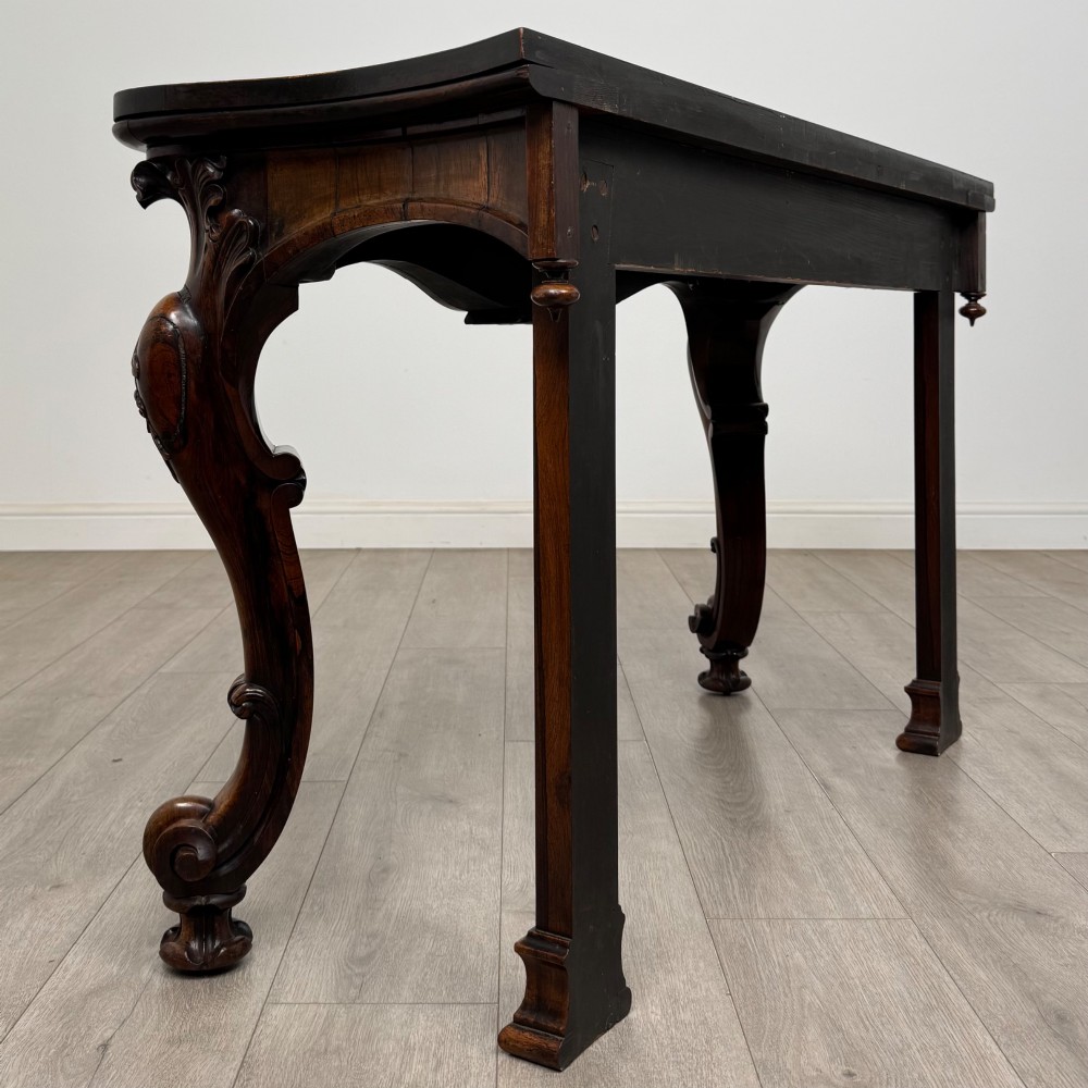 A 19th-century Victorian rosewood side table featuring hand-carved C-scroll ornament, a serpentine apron, and carved cabriole legs. View IV