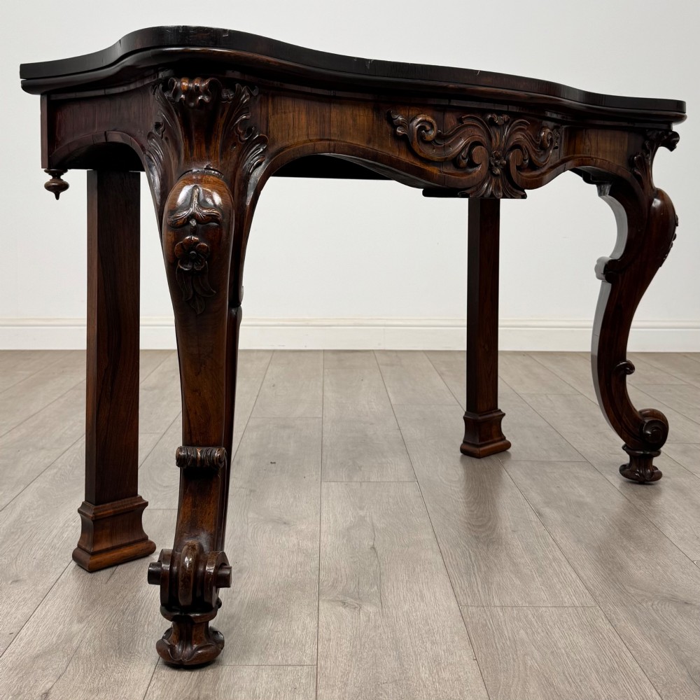 A 19th-century Victorian rosewood side table featuring hand-carved C-scroll ornament, a serpentine apron, and carved cabriole legs. View VIII