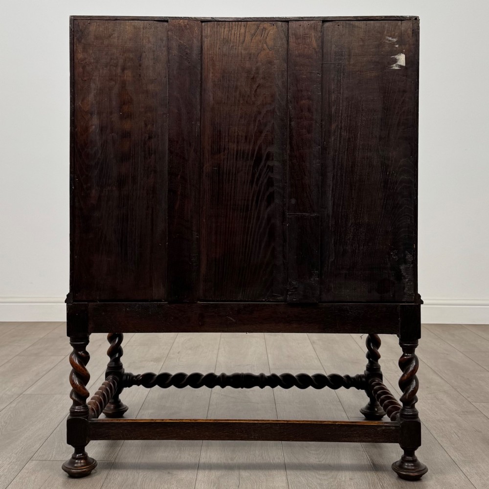 A dark oak Jacobean revival slant-front bureau featuring geometric panel mouldings, drop handles, and barley twist legs joined by stretchers. View VI