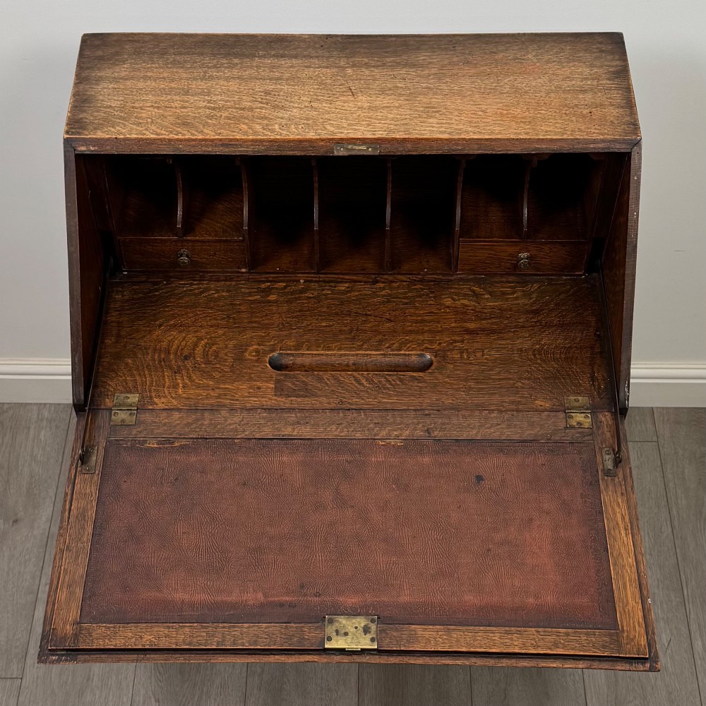 A dark oak Jacobean revival slant-front bureau featuring geometric panel mouldings, drop handles, and barley twist legs joined by stretchers. View XI