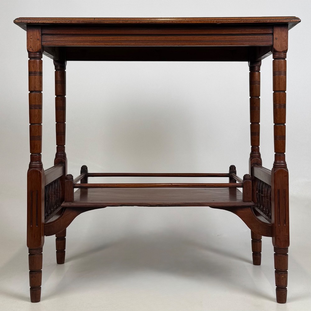 An Edwardian mahogany side table featuring turned legs and a lower shelf enclosed with spindle side rails.