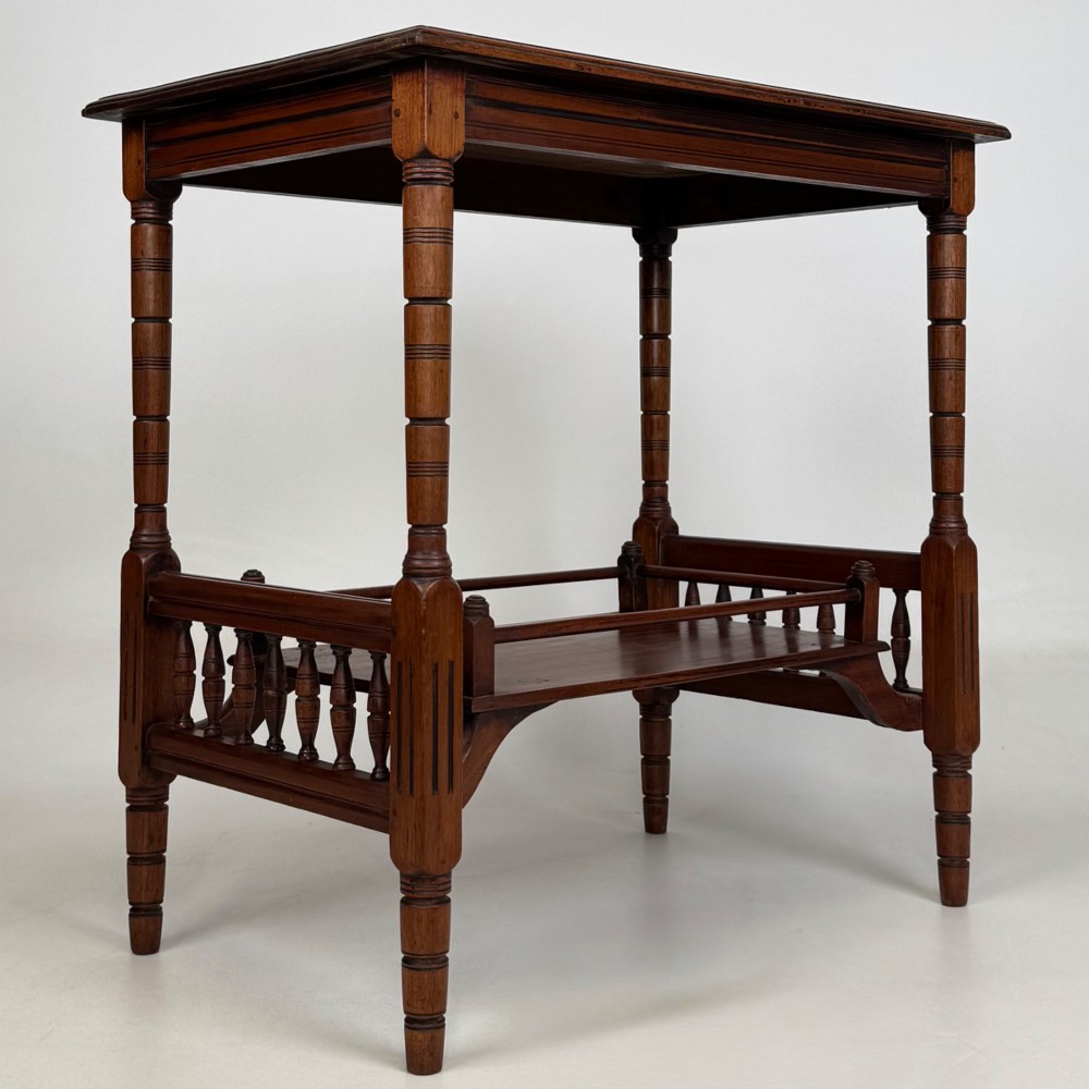 An Edwardian mahogany side table featuring turned legs and a lower shelf enclosed with spindle side rails. View IV