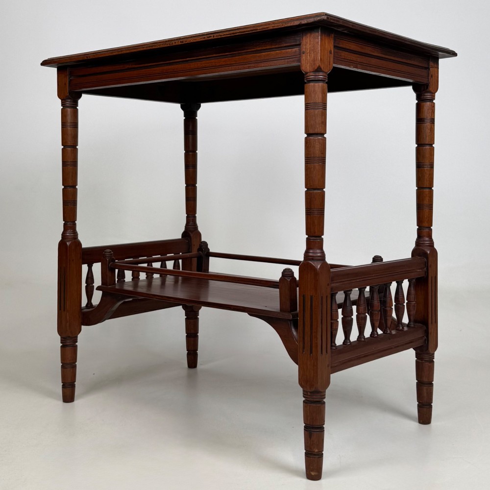 An Edwardian mahogany side table featuring turned legs and a lower shelf enclosed with spindle side rails. View VI