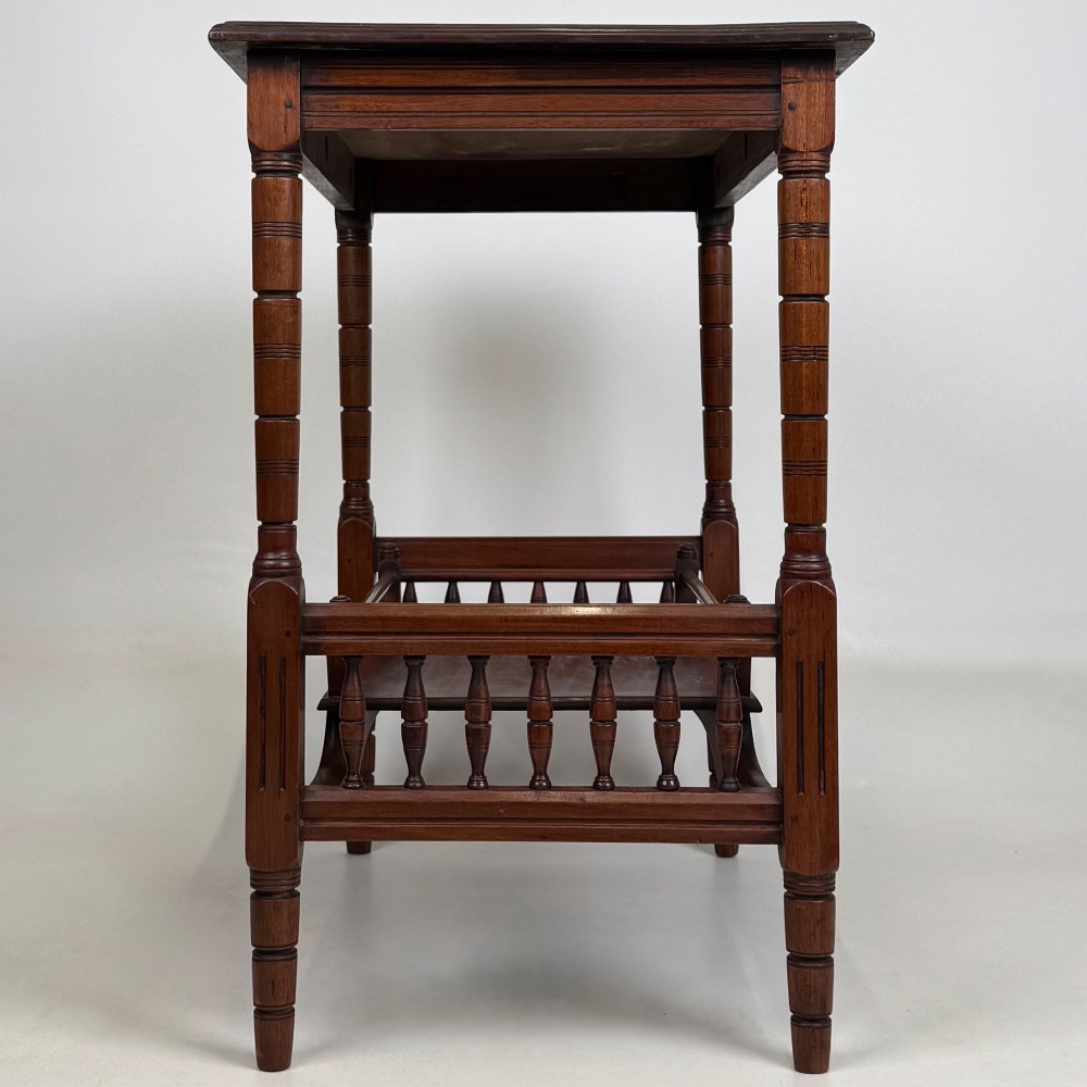 An Edwardian mahogany side table featuring turned legs and a lower shelf enclosed with spindle side rails. View VII