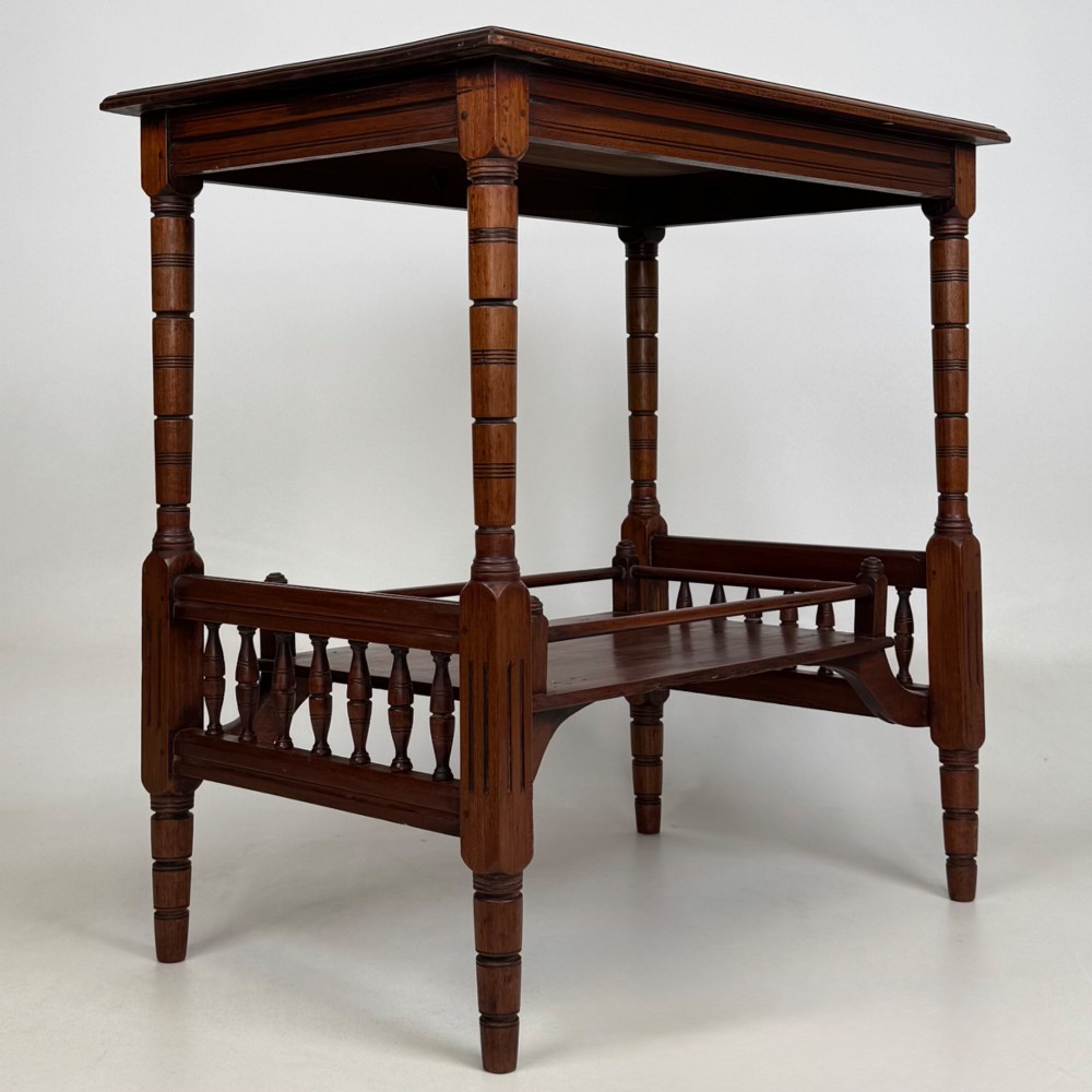 An Edwardian mahogany side table featuring turned legs and a lower shelf enclosed with spindle side rails. View VIII