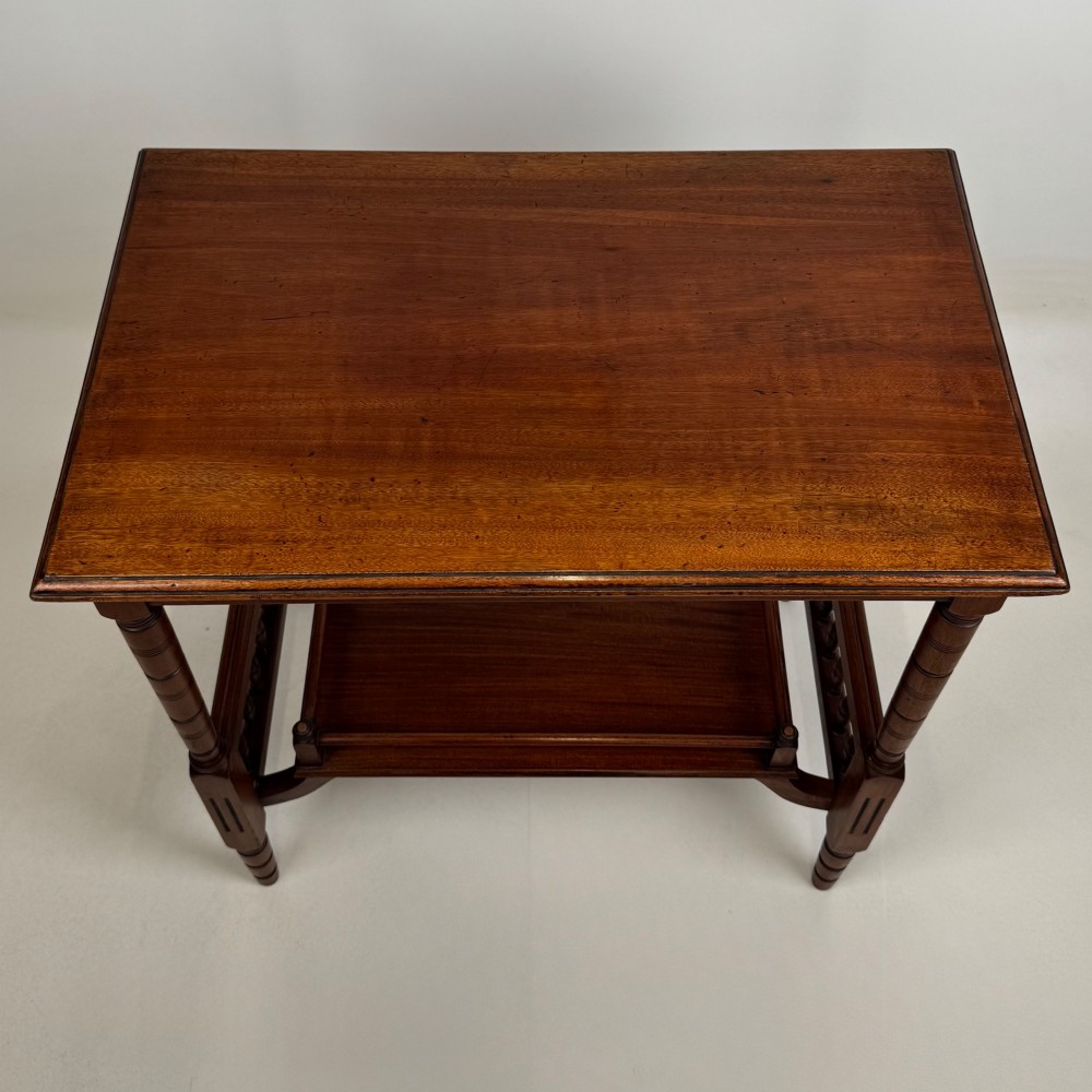 An Edwardian mahogany side table featuring turned legs and a lower shelf enclosed with spindle side rails. View IX