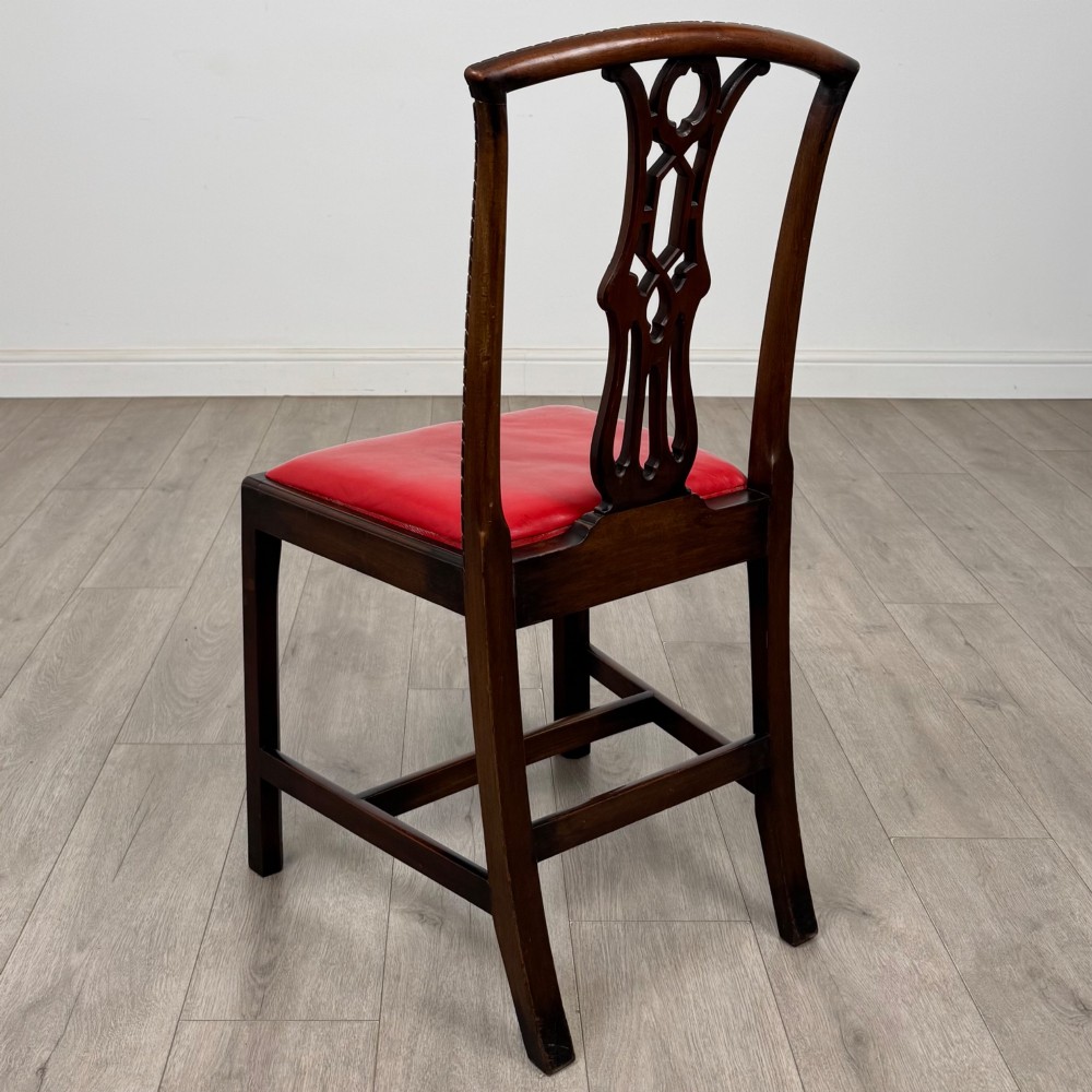 A set of six dark mahogany Georgian dining chairs featuring pierced back splats, straight legs with stretchers, and bright red leather drop-in seats. View IV