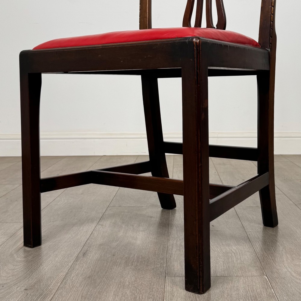 A set of six dark mahogany Georgian dining chairs featuring pierced back splats, straight legs with stretchers, and bright red leather drop-in seats. View VI