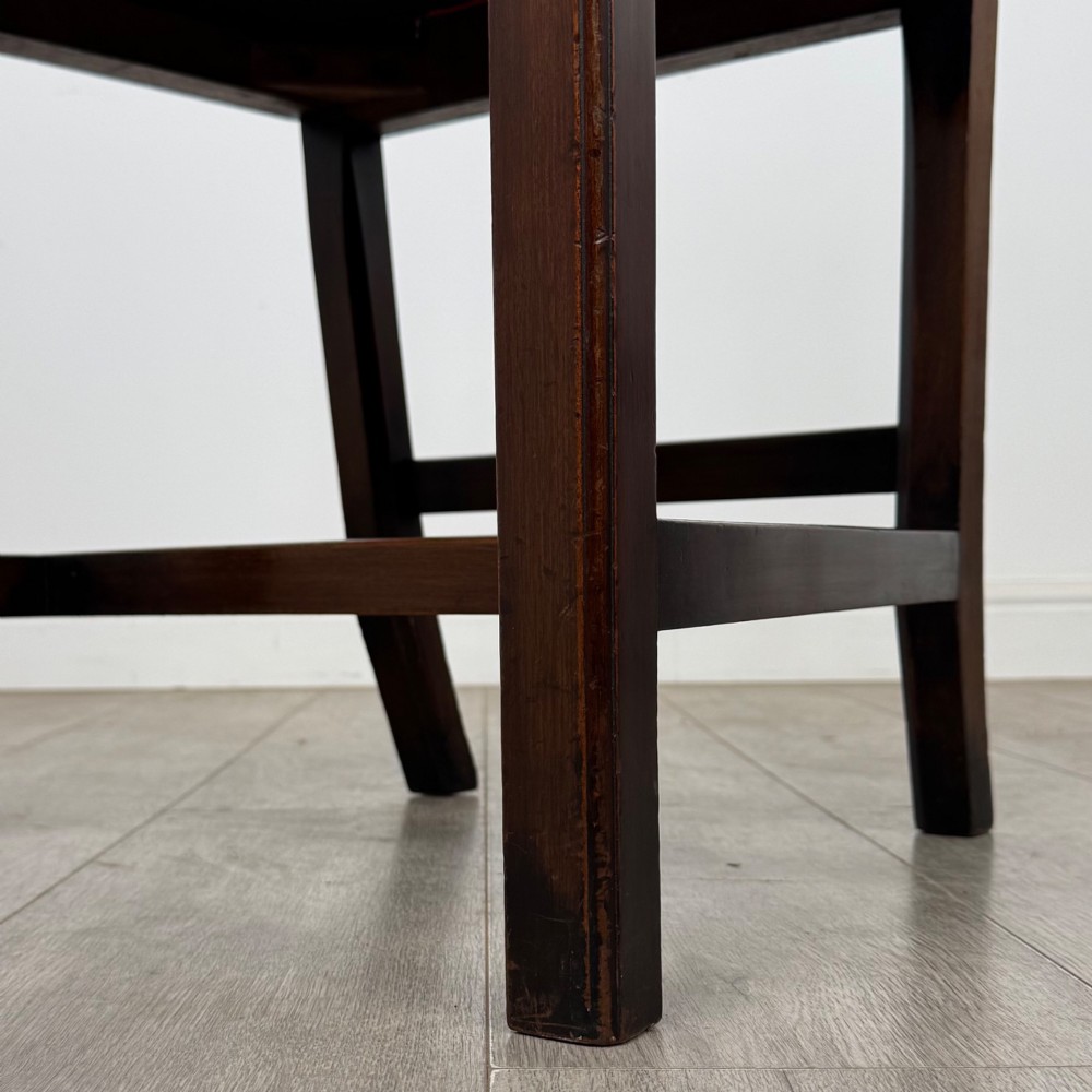 A set of six dark mahogany Georgian dining chairs featuring pierced back splats, straight legs with stretchers, and bright red leather drop-in seats. View VII