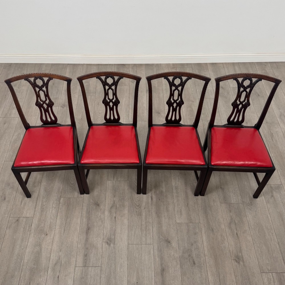 A set of six dark mahogany Georgian dining chairs featuring pierced back splats, straight legs with stretchers, and bright red leather drop-in seats. View VIII