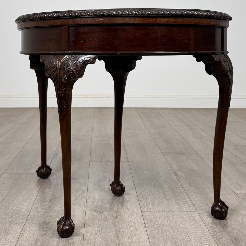 A circular dark mahogany card table featuring acanthus carved knees and cabriole legs terminating in ball and claw feet. View II