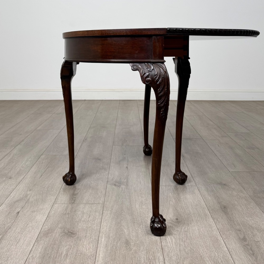 A circular dark mahogany card table featuring acanthus carved knees and cabriole legs terminating in ball and claw feet. View IV