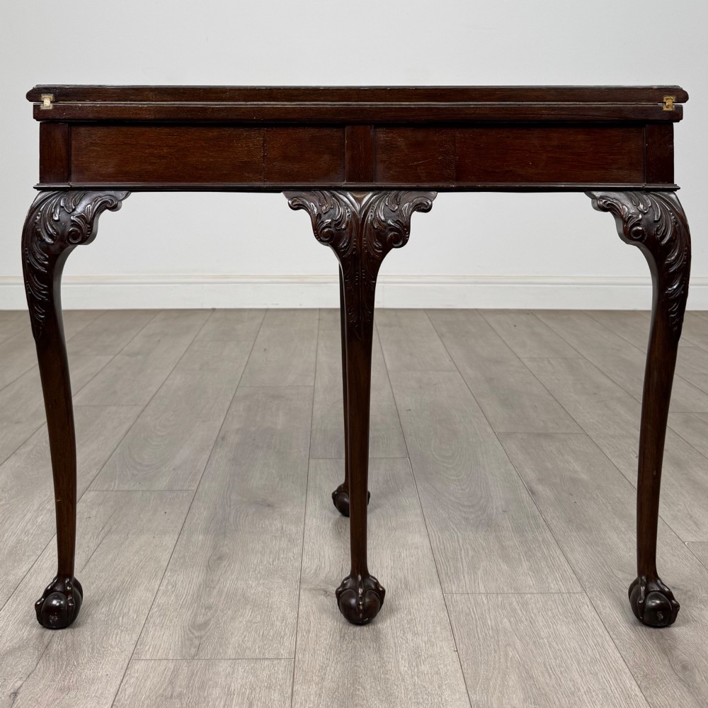 A circular dark mahogany card table featuring acanthus carved knees and cabriole legs terminating in ball and claw feet. View VI