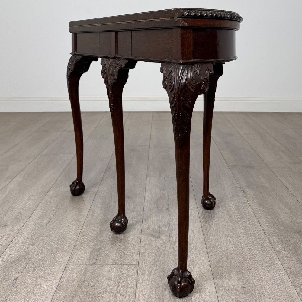 A circular dark mahogany card table featuring acanthus carved knees and cabriole legs terminating in ball and claw feet. View VII