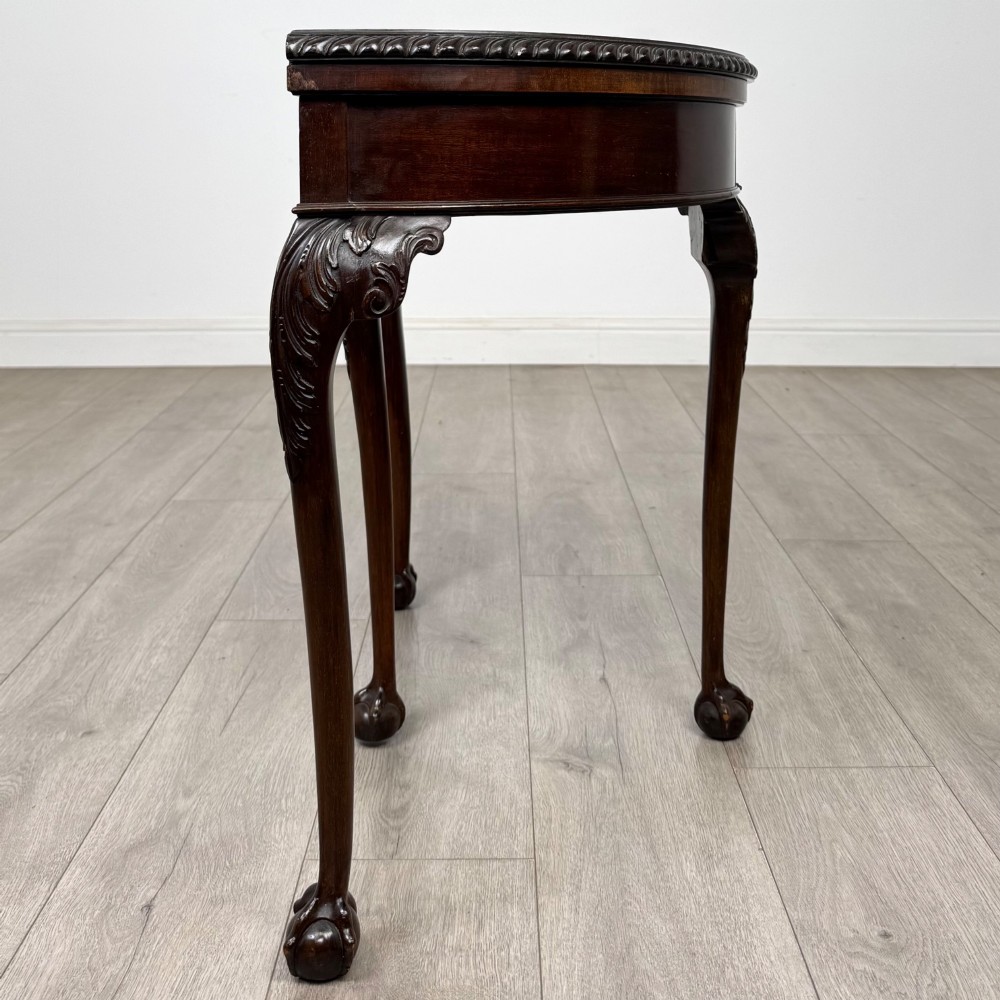 A circular dark mahogany card table featuring acanthus carved knees and cabriole legs terminating in ball and claw feet. View VIII