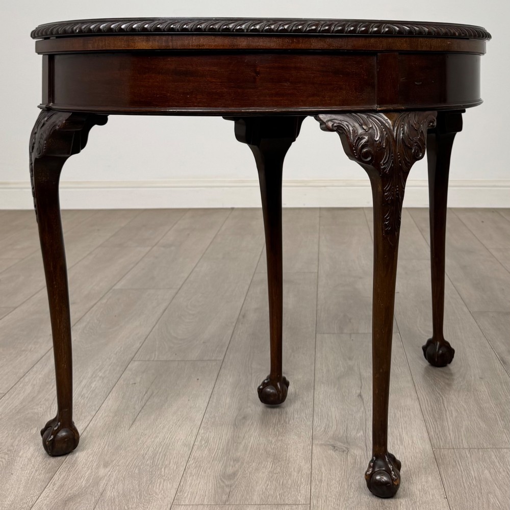 A circular dark mahogany card table featuring acanthus carved knees and cabriole legs terminating in ball and claw feet. View IX