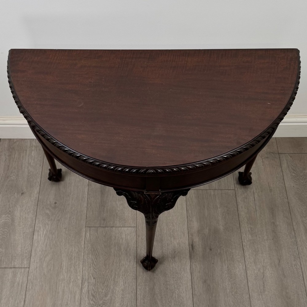 A circular dark mahogany card table featuring acanthus carved knees and cabriole legs terminating in ball and claw feet. View X