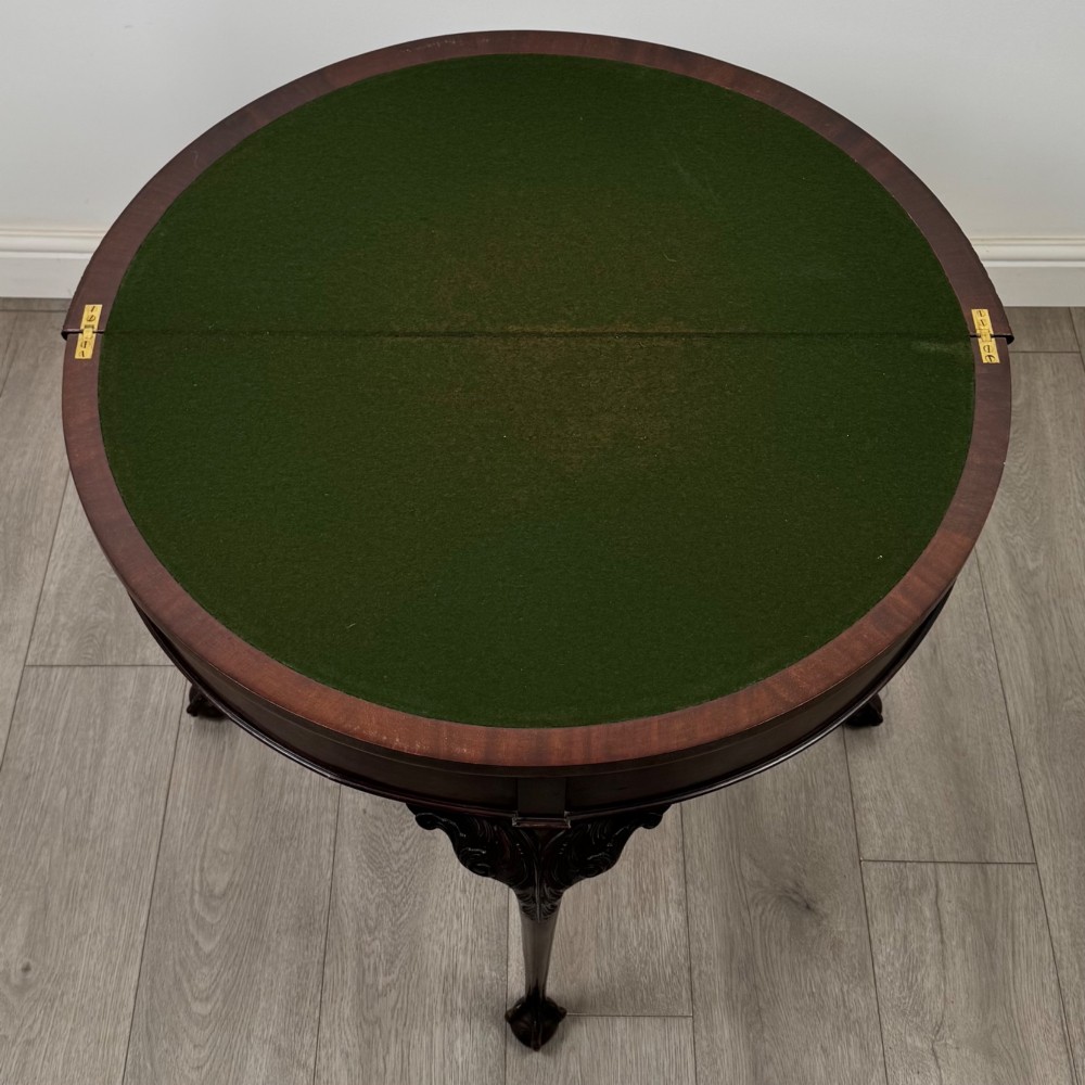 A circular dark mahogany card table featuring acanthus carved knees and cabriole legs terminating in ball and claw feet. View XI