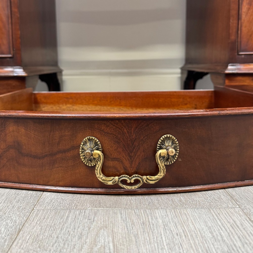 A twentieth-century mahogany kneehole desk featuring a serpentine front, multiple drawers with brass swan-neck handles, and bracket feet. View XI