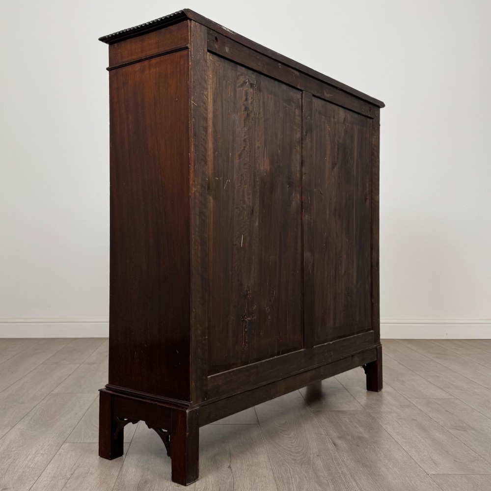 An Edwardian dark mahogany display cabinet featuring two glass doors with interlaced astragal glazing bars and internal wooden shelves. View V