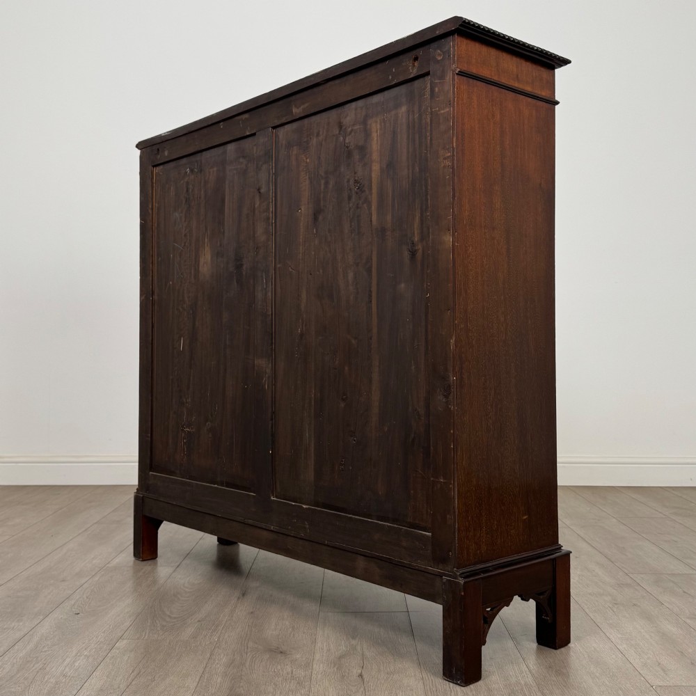 An Edwardian dark mahogany display cabinet featuring two glass doors with interlaced astragal glazing bars and internal wooden shelves. View VII