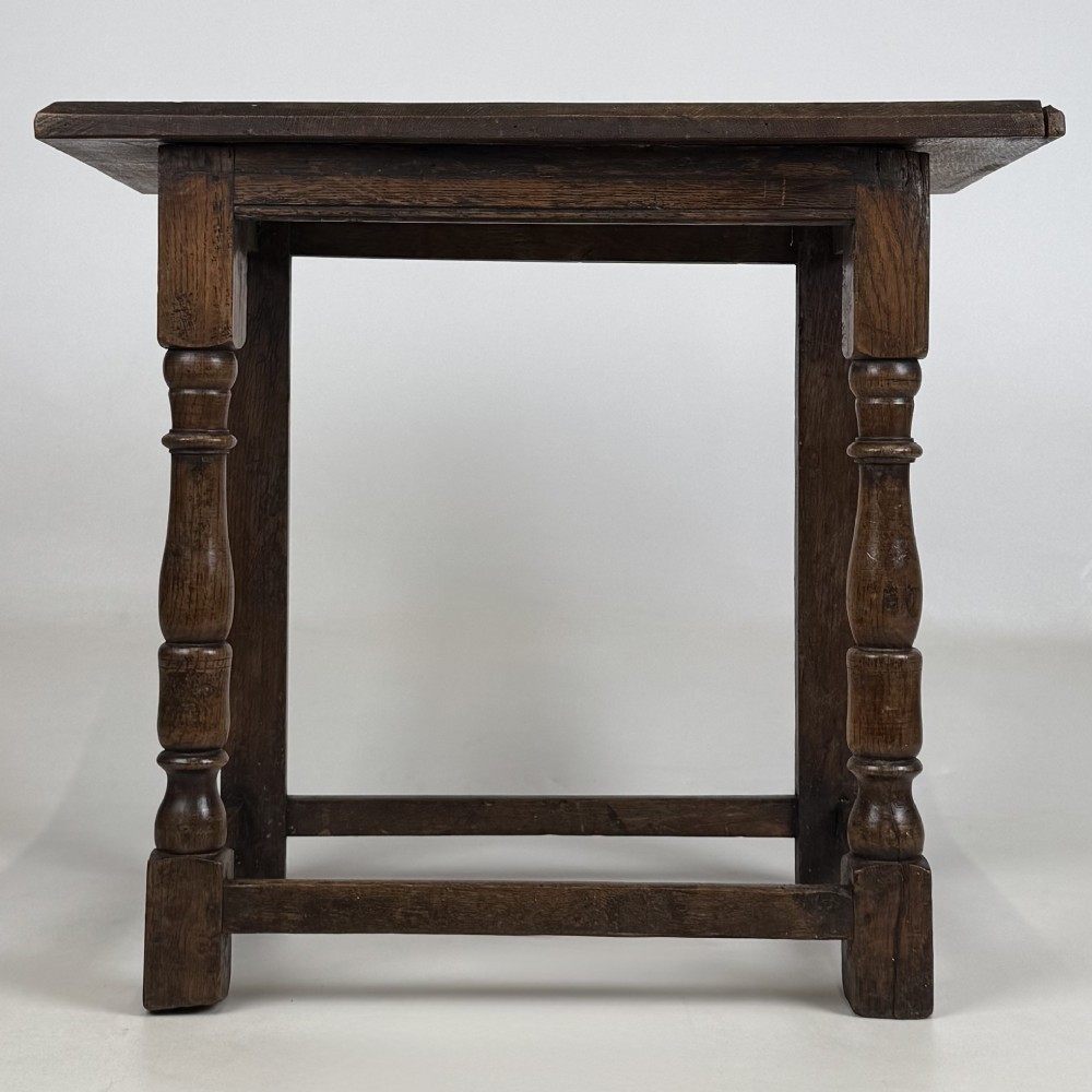 A 19th-century dark oak side table featuring a rectangular flat top, turned baluster legs, and sturdy lower stretchers.