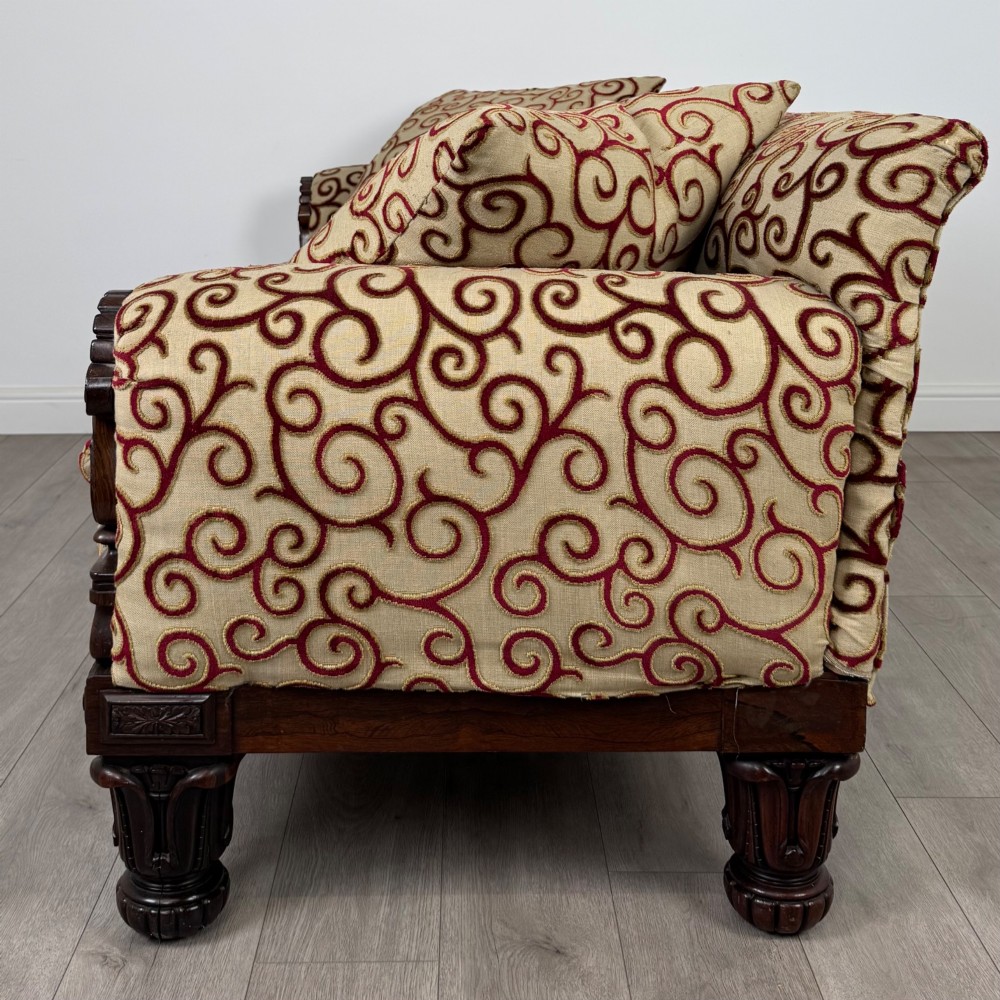 A 19th-century William IV sofa crafted from dark rosewood with carved scroll arms, turned legs, and swirl-patterned cream and burgundy fabric upholstery. View III