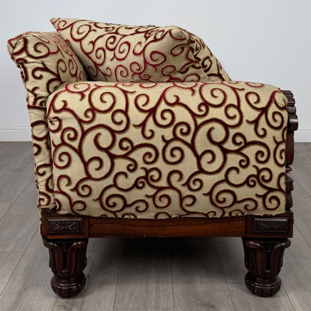 A 19th-century William IV sofa crafted from dark rosewood with carved scroll arms, turned legs, and swirl-patterned cream and burgundy fabric upholstery. View VII