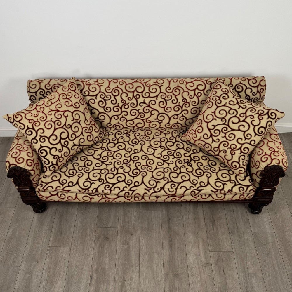 A 19th-century William IV sofa crafted from dark rosewood with carved scroll arms, turned legs, and swirl-patterned cream and burgundy fabric upholstery. View IX