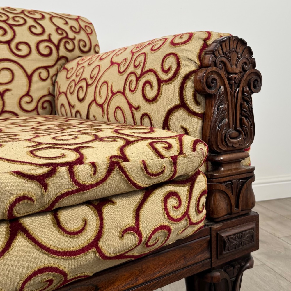 A 19th-century William IV sofa crafted from dark rosewood with carved scroll arms, turned legs, and swirl-patterned cream and burgundy fabric upholstery. View X