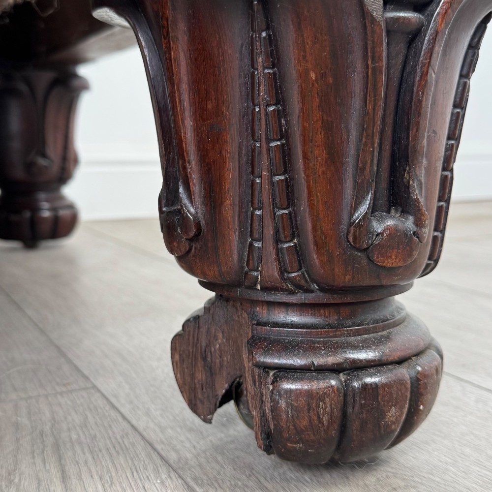 A 19th-century William IV sofa crafted from dark rosewood with carved scroll arms, turned legs, and swirl-patterned cream and burgundy fabric upholstery. View XII