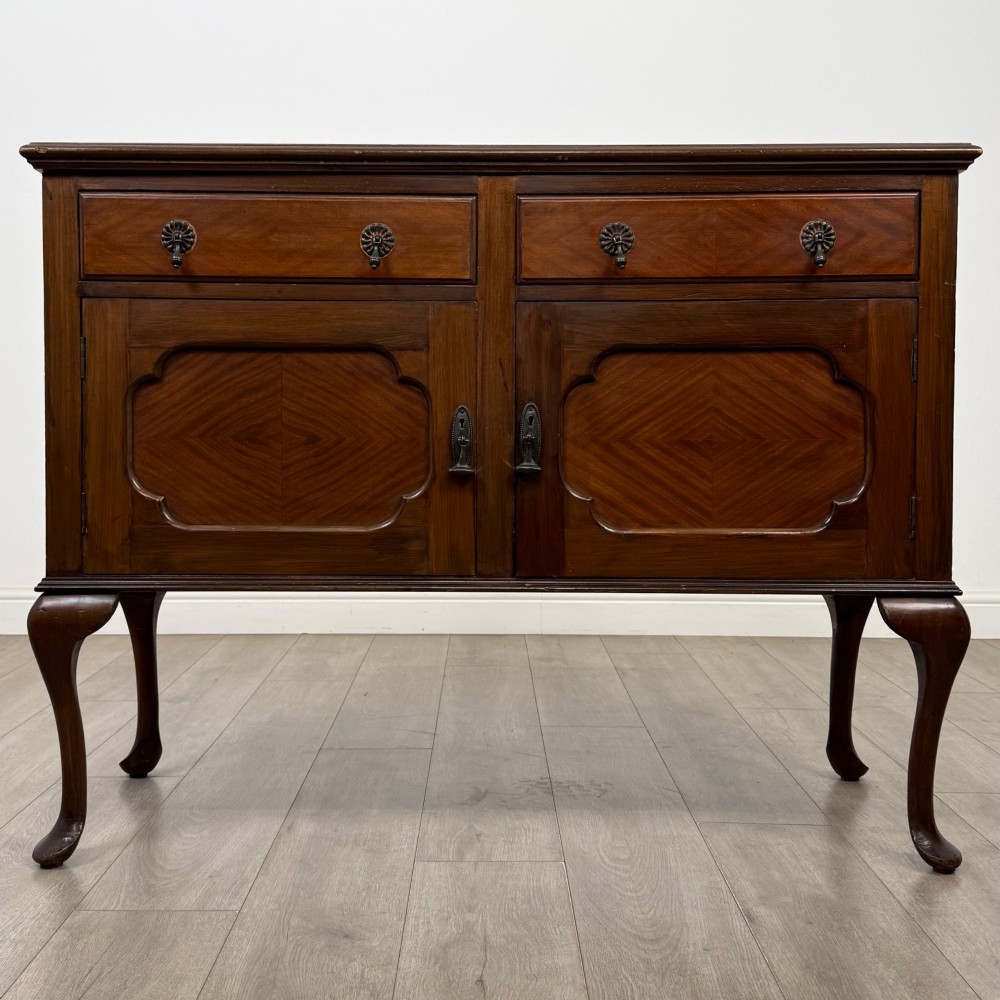 An Edwardian mahogany sideboard featuring two top drawers above a two-door cabinet supported on slender cabriole legs.