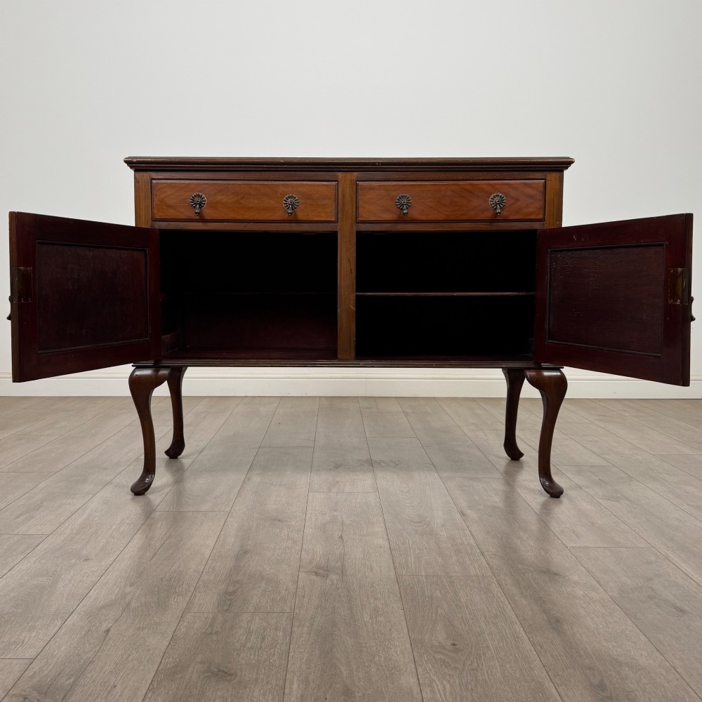 An Edwardian mahogany sideboard featuring two top drawers above a two-door cabinet supported on slender cabriole legs. View II