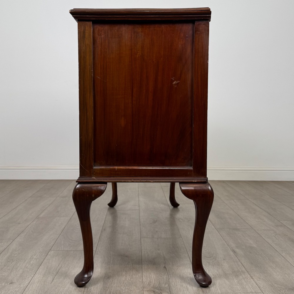 An Edwardian mahogany sideboard featuring two top drawers above a two-door cabinet supported on slender cabriole legs. View IV