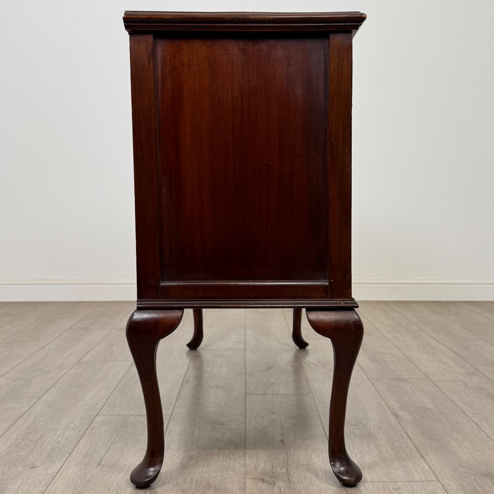 An Edwardian mahogany sideboard featuring two top drawers above a two-door cabinet supported on slender cabriole legs. View VIII