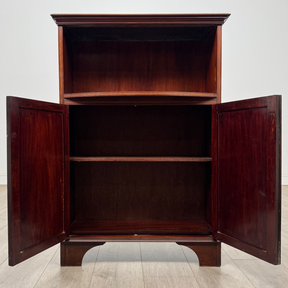 An Edwardian dark mahogany cabinet with an open upper shelf, two lower inlaid cupboard doors, and shaped bracket feet. View III