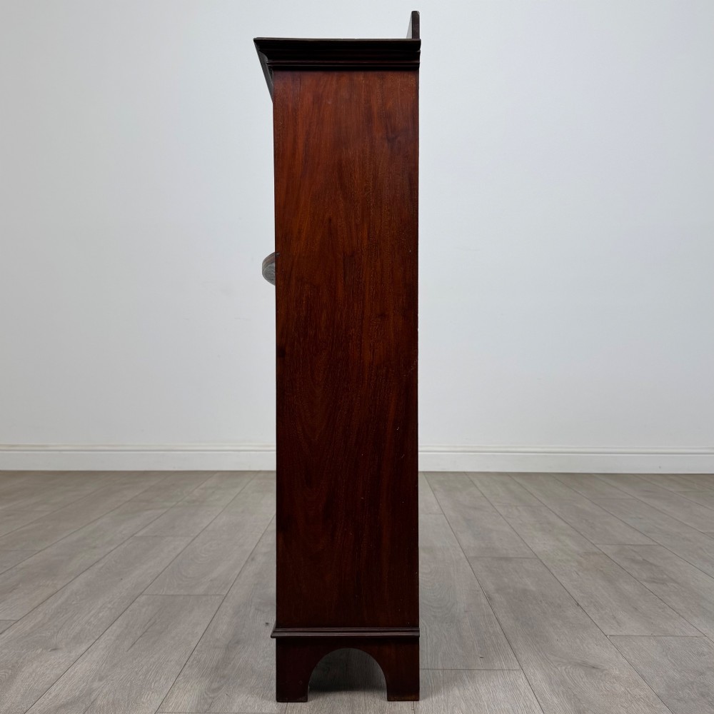 An Edwardian dark mahogany cabinet with an open upper shelf, two lower inlaid cupboard doors, and shaped bracket feet. View V